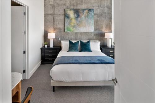 ein Schlafzimmer mit einem großen Bett mit blauen Kissen in der Unterkunft Luxury 2BR 2BA Penthouse-Pool, Gym, Pkg, Views! in Salt Lake City