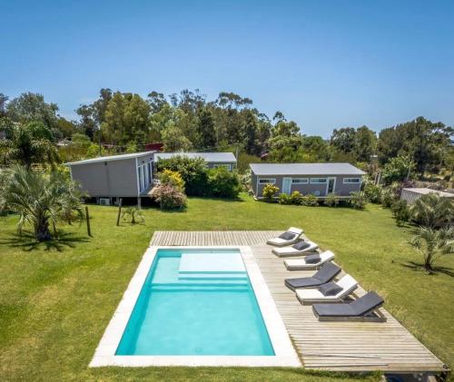 ein Swimmingpool mit Liegestühlen und ein Haus in der Unterkunft Hus Punta Rubia in La Pedrera