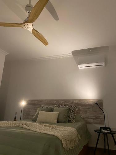 ein Schlafzimmer mit einem Bett mit Deckenventilator in der Unterkunft A Janela do Cantinho in Reguengos de Monsaraz