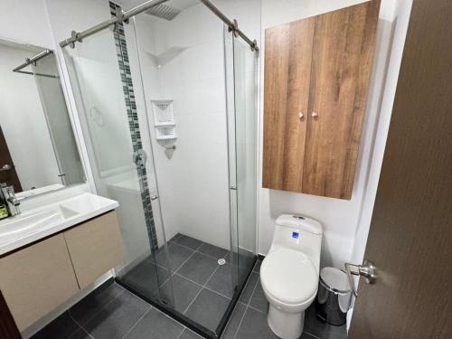 a bathroom with a shower and a toilet and a sink at Club house 1105-Apartamento Fundadores con balcón, piscina, gym in Armenia