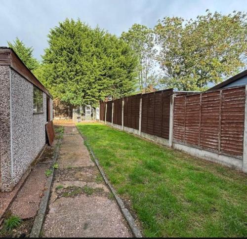 une cour vide avec clôture et pelouse dans l'établissement Blackthorne House, à Birmingham