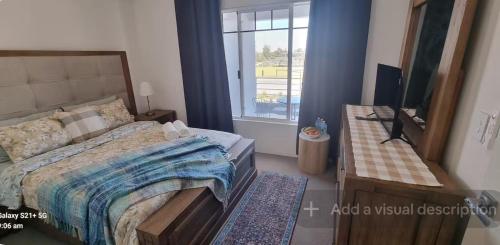 a bedroom with a bed and a tv and a window at Quiet Room with Ensuite, Kitchenette, Veranda & Lake View in Kelmscott