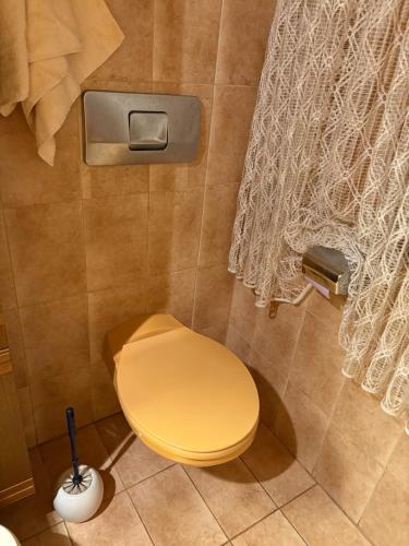 a bathroom with a yellow toilet in a shower at Ferienwohnung Jägerhaus in Walldürn