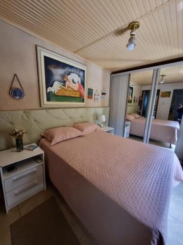 ein Schlafzimmer mit einem Bett und einem Gemälde an der Wand in der Unterkunft Coração de São Gabriel in São Gabriel