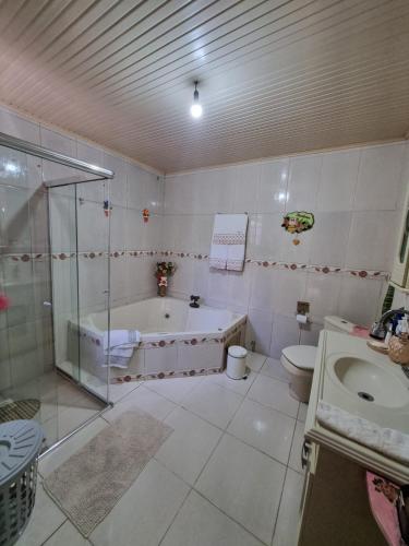 ein Badezimmer mit einer Dusche, einer Badewanne und einem WC in der Unterkunft Coração de São Gabriel in São Gabriel