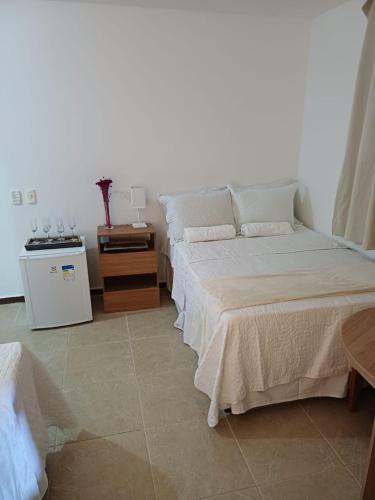 a bedroom with two beds and a night stand at Villa Búzios in Nísia Floresta