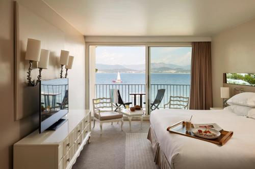 a hotel room with a bed and a view of the ocean at Sofitel Golfe d'Ajaccio Thalassa Sea & Spa in Ajaccio