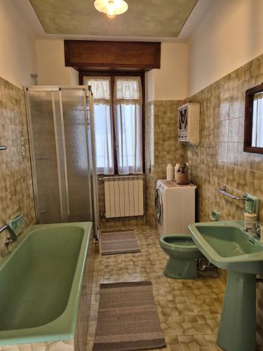 ein Badezimmer mit einer grünen Badewanne, einer Toilette und einem Waschbecken in der Unterkunft Appartamento in struttura indipendente Appartamenti di Mezzo in Cecino