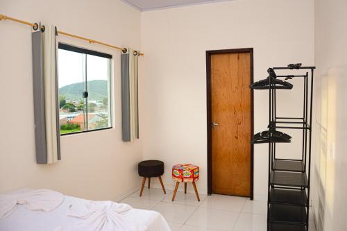 a bedroom with a bed and a ladder and a window at Suíte no cidade Jardim in Parauapebas