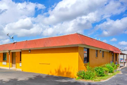 a yellow and red building with a red roof at Budget Inn By OYO Edinburg Hwy 281 in Edinburg
