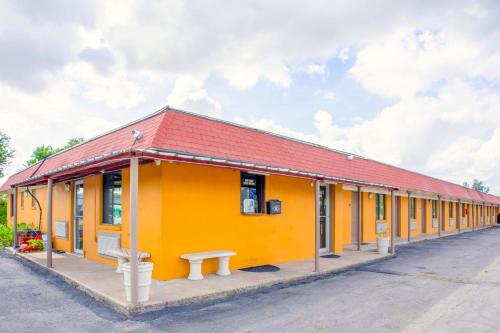 a yellow building with a red roof at Budget Inn By OYO Edinburg Hwy 281 in Edinburg