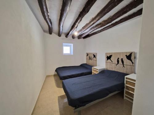 twee bedden in een kamer met witte muren bij Cortijo el Galardón 