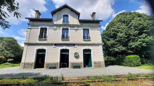 Ein altes weißes Gebäude mit einer Uhr drauf. in der Unterkunft La gare de Chambretaud in Chambretaud