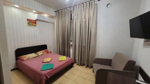 ein kleines Zimmer mit einem Bett und einem Stuhl in der Unterkunft Apartment in the city centr Bursatsky descent in Kharkov