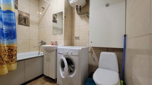 ein Badezimmer mit Waschmaschine und Waschbecken in der Unterkunft Apartment in the city centr Bursatsky descent in Kharkov
