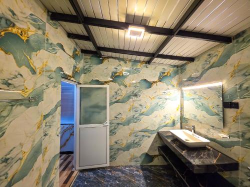 ein Badezimmer mit Waschbecken und Spiegel in der Unterkunft White Moon Cabin & Cottage in Ella