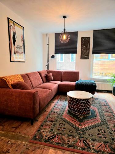 a living room with a brown couch and a table at Homely 2Bedroom in the Center of Eindhoven in Eindhoven