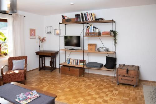 a living room with a television on a shelf at Altstadtwohnung mit Salzachblick in Burghausen