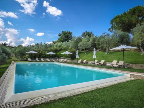 une piscine avec chaises et parasols dans l'établissement Historic Farmhouse Overlooking San Gimignano, à San Gimignano