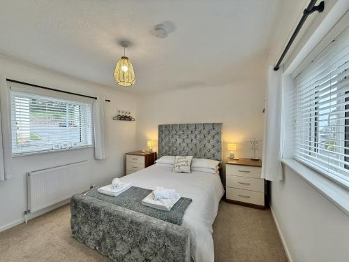 a bedroom with a bed and a desk and windows at SubLyme in Lyme Regis
