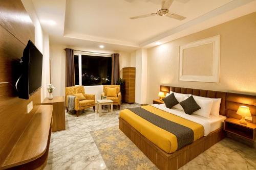 a hotel room with a bed and a chair at Hotel LAA Meridian, Har Ke Pauri Road - Haridwar in Haridwār