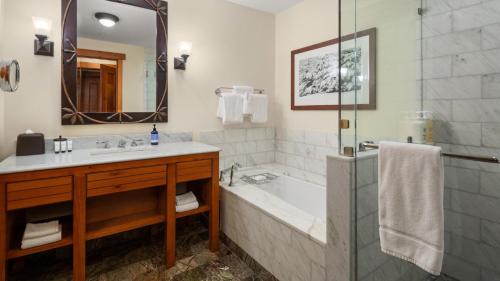 une salle de bain avec une baignoire, un lavabo et une douche dans l'établissement 1334 Studio Spruce Peak Lodge Sleeps 4 Ski in Ski Out, à Stowe Mountain