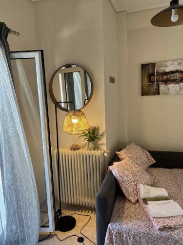 アテネにあるKontaStudioの鏡とベッドとランプ付きの部屋