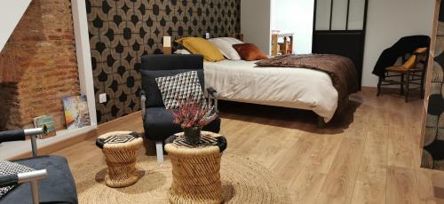 a bedroom with a bed and a chair and a table at Carpe Diem in Saint-Savin