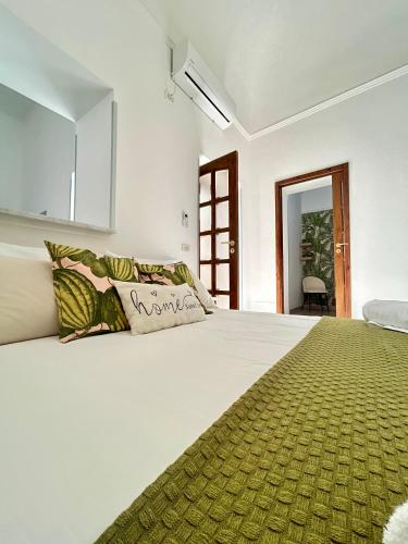 a white bedroom with a large bed and a window at Sweet Home in Vico Equense
