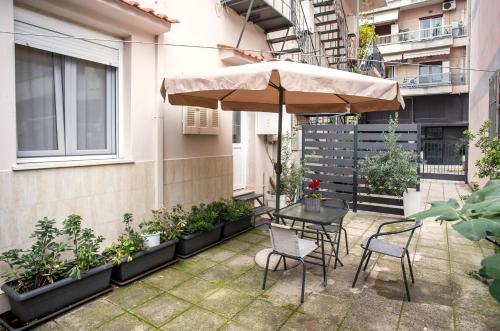a patio with a table and chairs and an umbrella at City Central Apartment with Parking in Larisa
