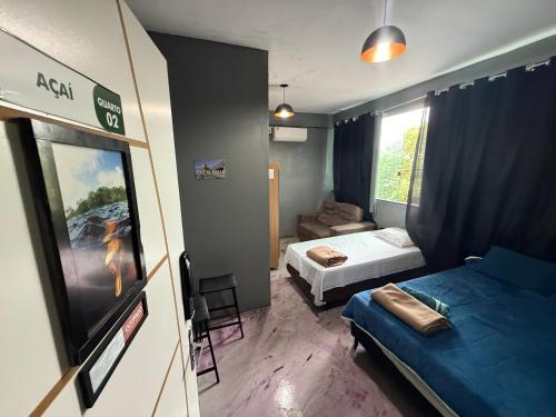 a small room with two beds and a tv at Hotel e Restaurante Casa Paraense Original, px ao aeroporto in Manaus