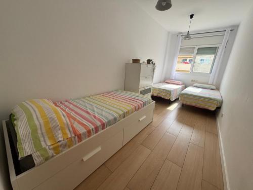a small bedroom with two beds and a window at Apartamento Clotilde Lloret in Lloret de Mar