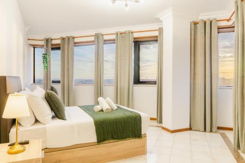 a bedroom with a large bed with windows at Vistoso Alto Palace in Lisbon