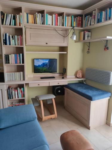 a living room with a desk with a tv and books at Ciliano 16 in Montepulciano