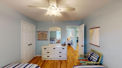 een slaapkamer met een witte dressoir en een spiegel bij Beach Oaks in Jekyll Island