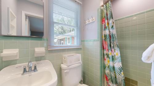 een badkamer met een wastafel, een toilet en een spiegel bij Beach Oaks in Jekyll Island