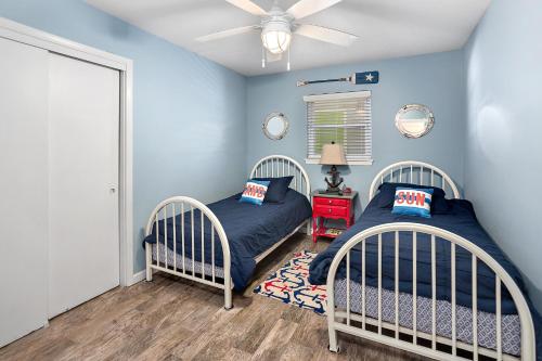 a bedroom with two beds and a ceiling fan at Sweetpeas Cottage in Jekyll Island