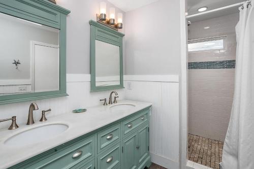 a bathroom with two sinks and a shower at Sweetpeas Cottage in Jekyll Island