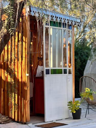 a greenhouse with a white door on a patio at YogaLife in Mercedes