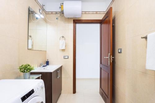 ein Badezimmer mit Toilette und Waschbecken und einer Tür in der Unterkunft Brisa - Armonía Park, Bajamar in El Puertito