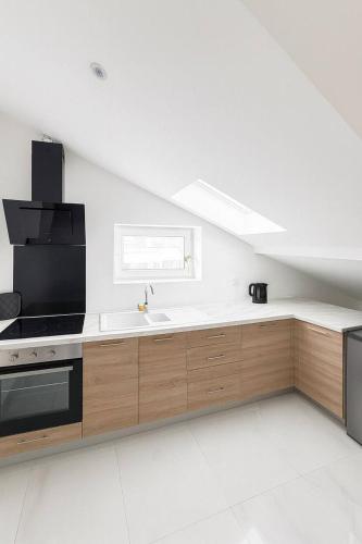 eine weiße Küche mit Spüle und Herd in der Unterkunft DeLuxe Studio Lumineux, Rénové, Parking Gratuit, MULHOUSE CENTRE in Mulhouse