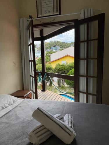 a room with a bed with a view of a balcony at Pousada Kaianoá in Arraial do Cabo