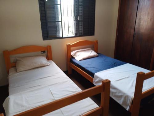 two twin beds in a room with a window at Casa do Comendador in Uberaba