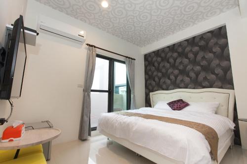 a bedroom with a bed and a tv and a window at Candy House in Wujie