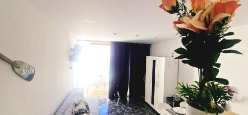 ein Zimmer mit einer Vase mit Blumen an der Wand in der Unterkunft MARINE HOME in Costa Del Silencio