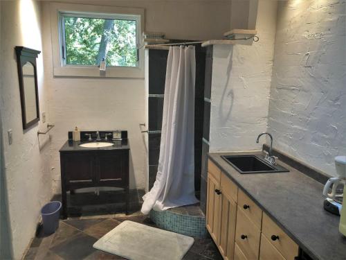 een badkamer met een wastafel en een douchegordijn bij Kisses Cottage in Jekyll Island