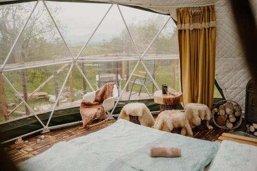 a room with a bed and a large window at Wild Glamping Liptov in Liptovský Ondrej