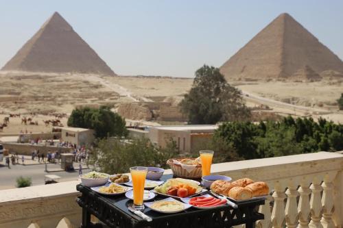 un vassoio di cibo su un balcone con le piramidi di Soul Scarab Pyramids View a Il Cairo