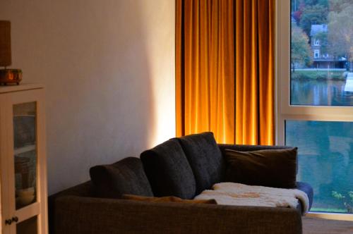 a couch in a living room with a window at Ferienwohnung Grüne Boje in Bullay