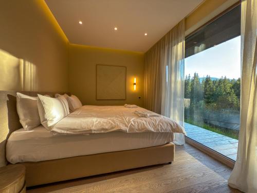 a bedroom with a bed and a large window at Eho Resort in Ilʼtsya Gurny